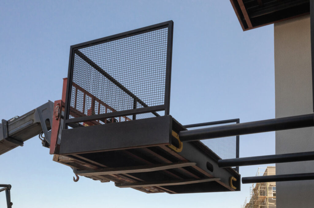 An image of the black steel support system being installed on the side of a building with the aid of a forklift